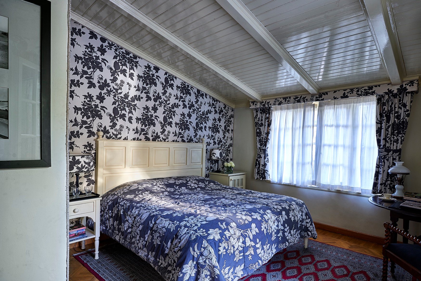 Guest room with blue floral textiles at Villa Belle Époque