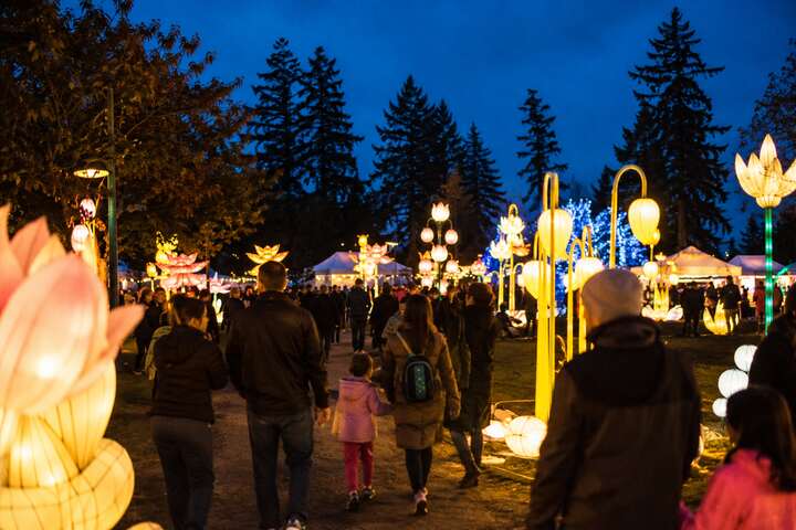 Families walking among glowing lantern installations at the Luminary Festival in North Delta BC