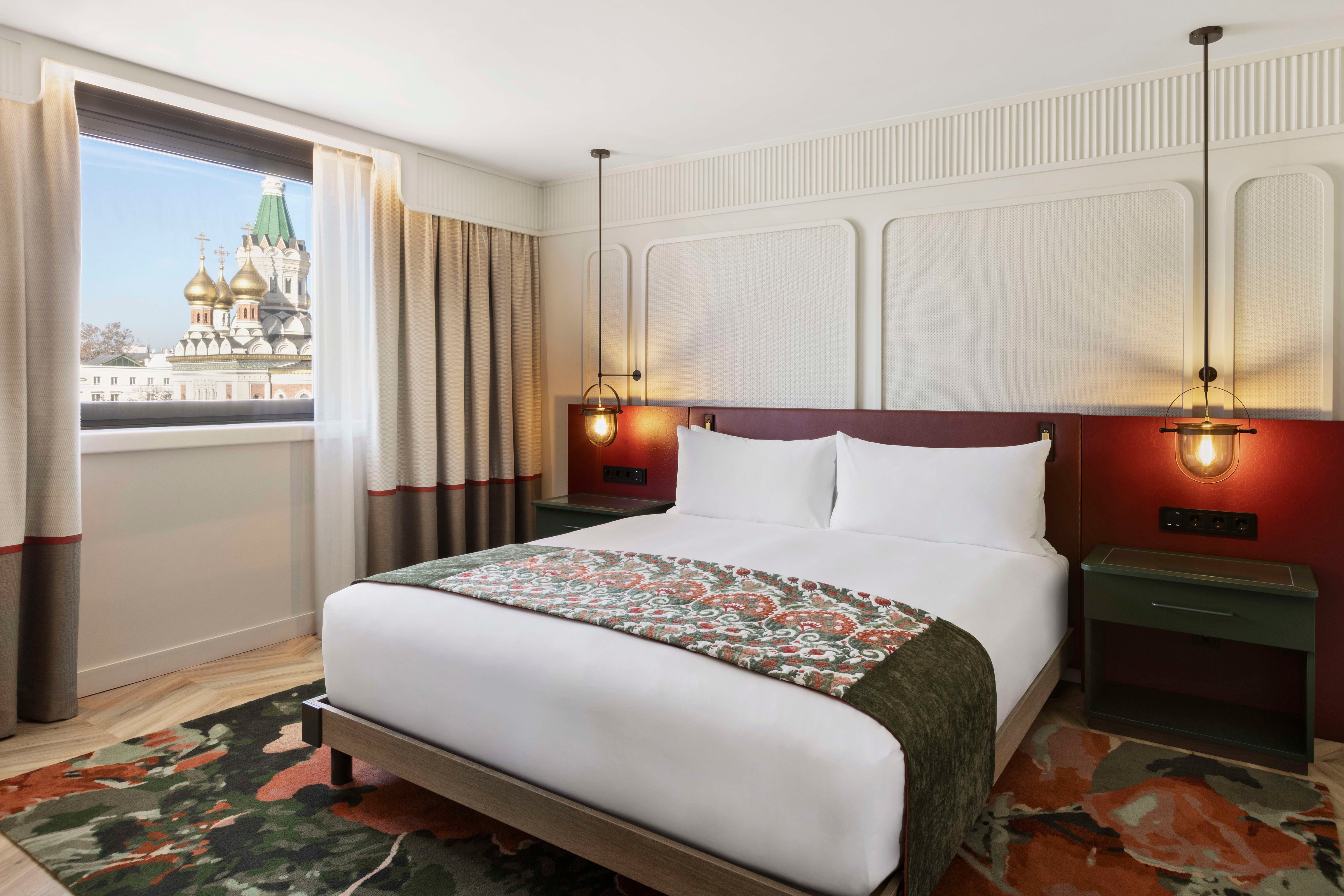 Guest room with a floral bedspread and a view of Vienna at the Imperial Riding School