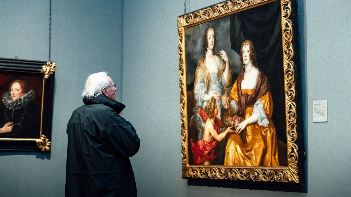 An older man in a dark coat studying a large gold-framed portrait in a gallery