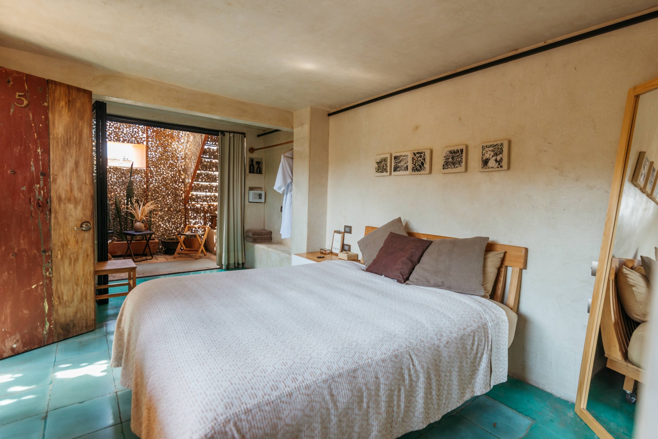 Guest room with pale blue floor tiles and local artwork