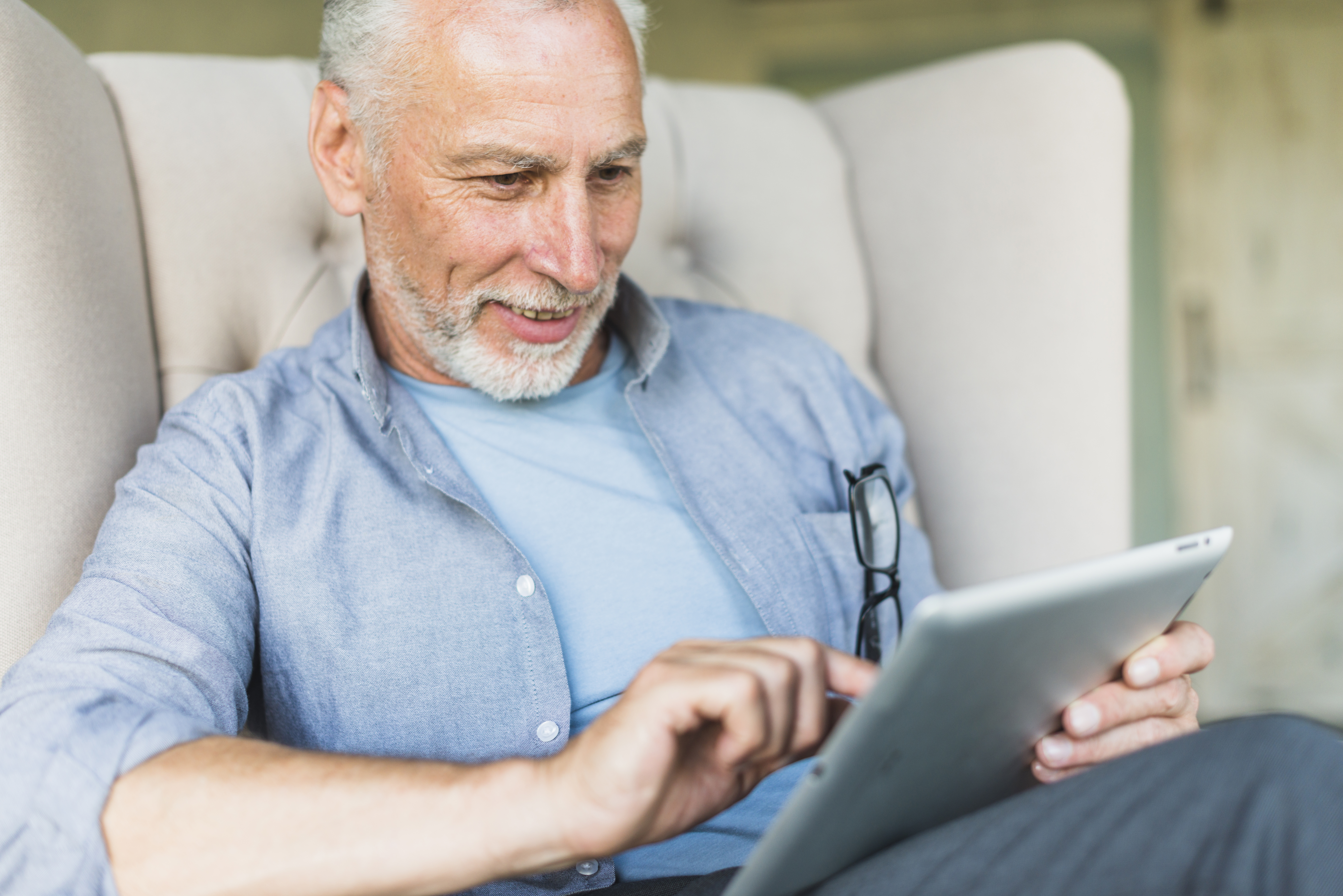 A man enjoying the 65Nation Insider newsletter on his tablet
