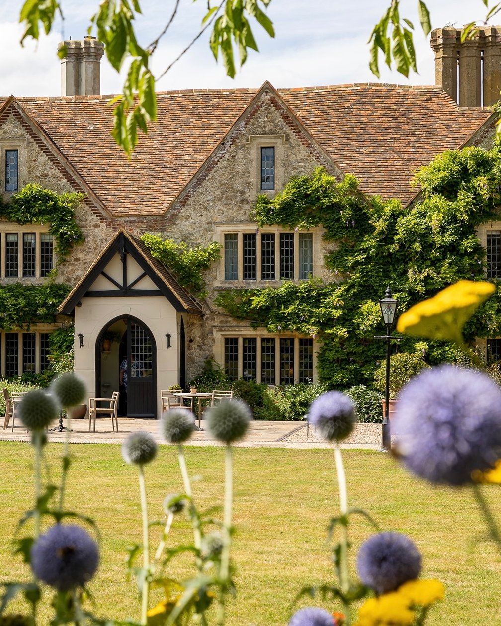 Historic Boys Hall framed by flowering gardens