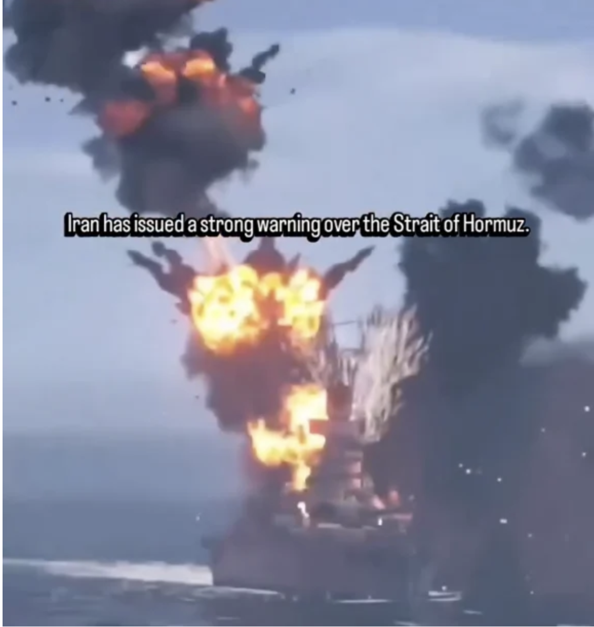 An aircraft carrier struck by a missile with a stiff, digitally added American flag that doesn't react to the explosion beside it