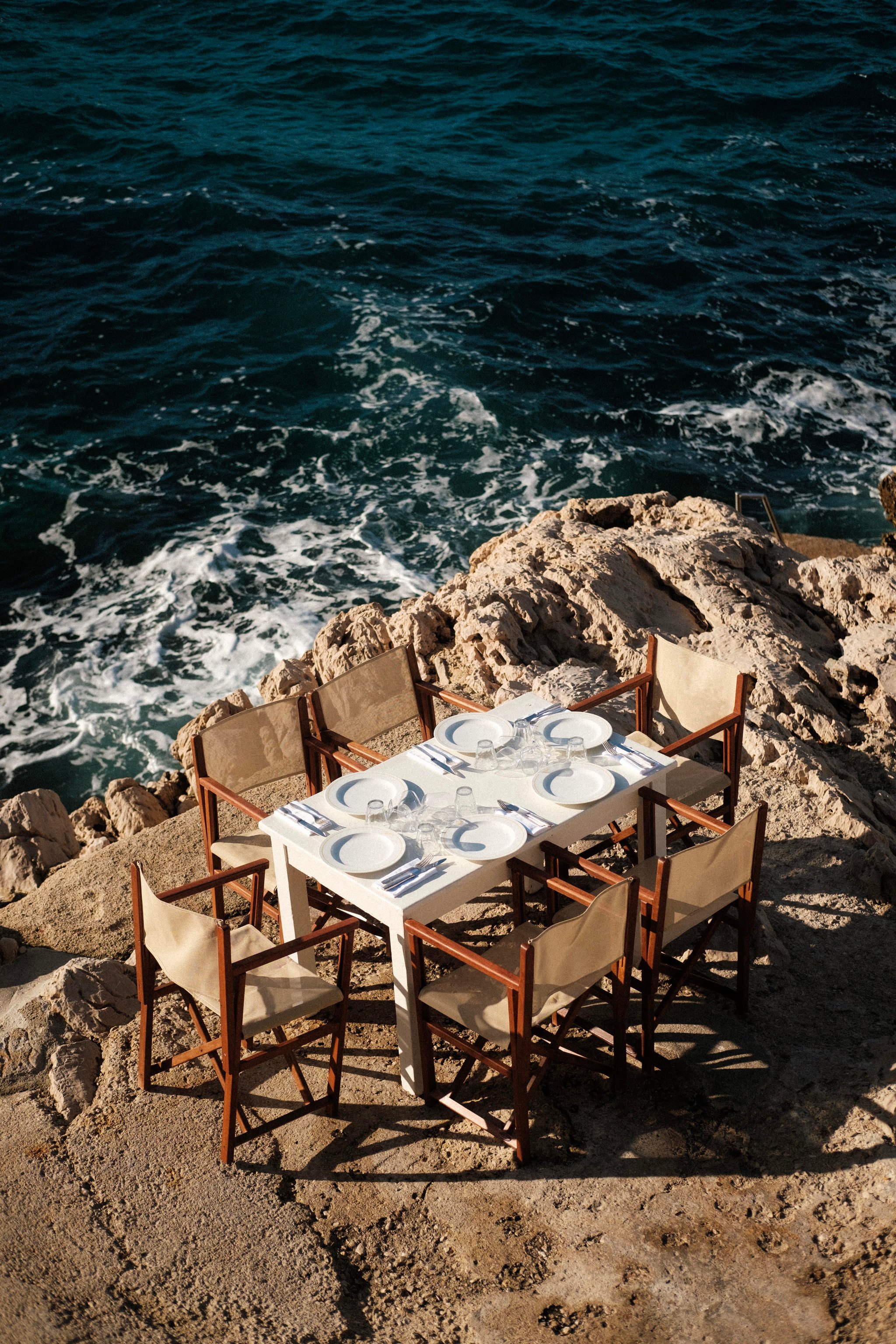 Dining table perched on the rocks above the Mediterranean at Tuba Club
