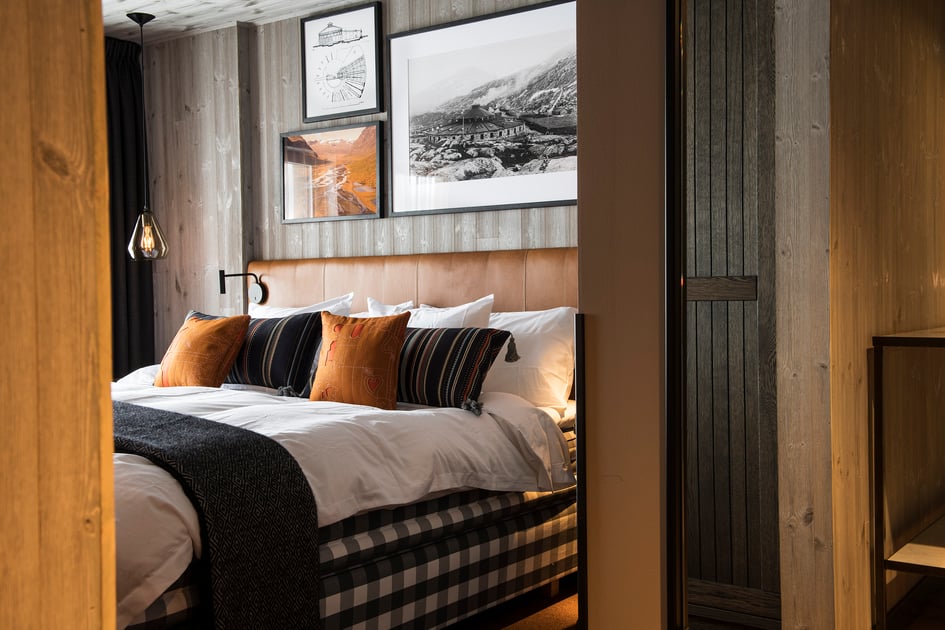 Cozy guest room with checked bedding and warm wood paneling