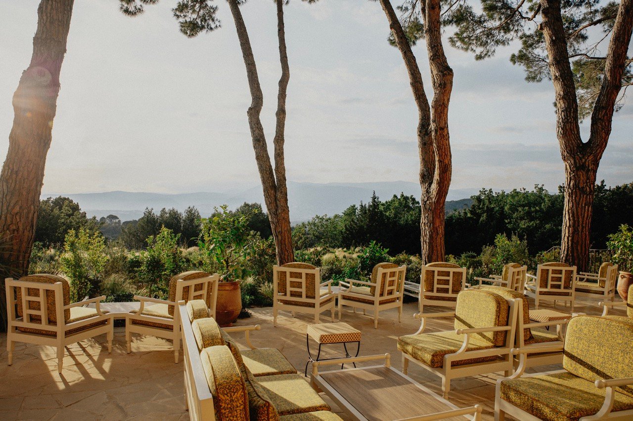 Terrace seating beneath pine trees above the Riviera