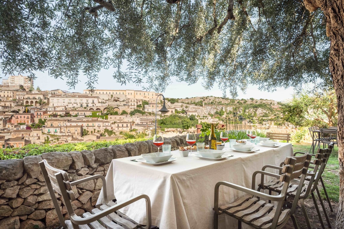 Breakfast table beneath olive trees at Casa Talia