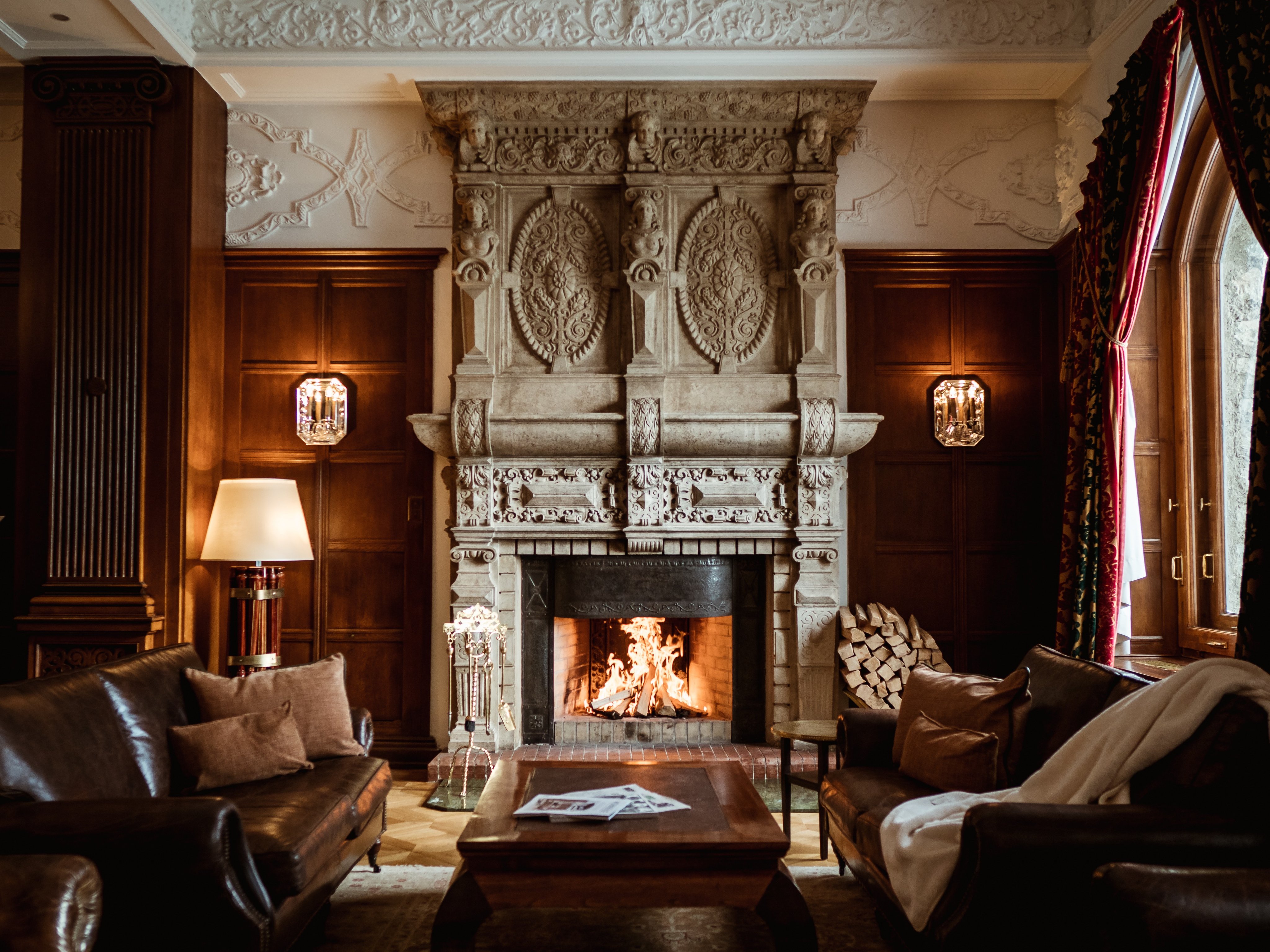 Historic carved fireplace and lounge seating at Carlton Hotel St. Moritz