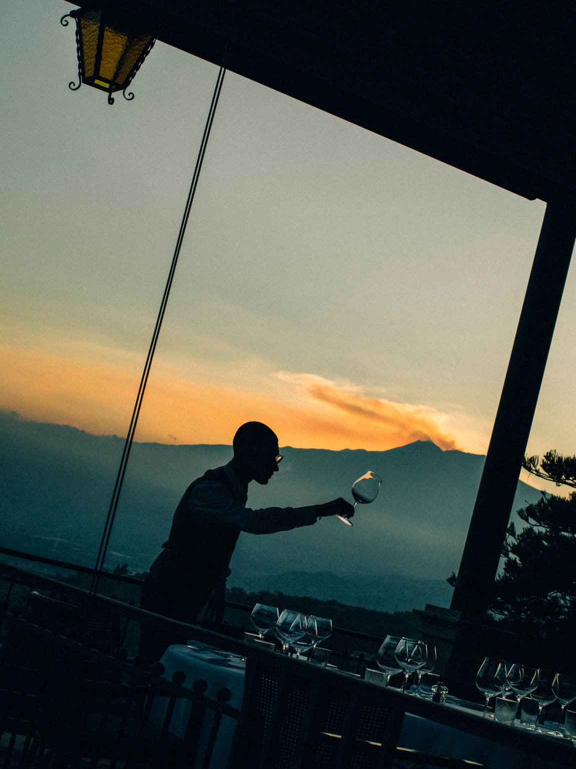 Bartender preparing a drink against a sunset view