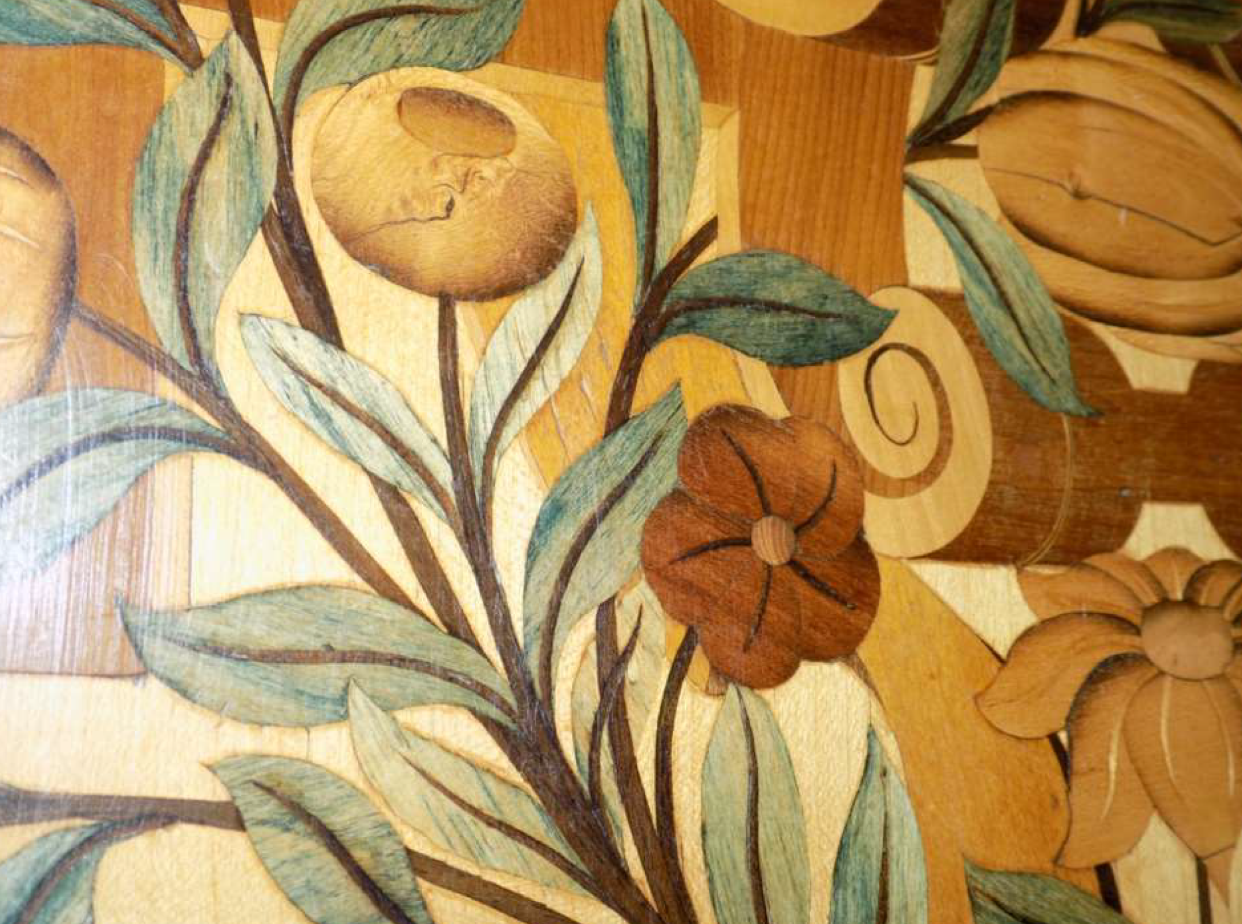 Inlaid wooden flowers in honey and brown, with soft blue-green leaves.