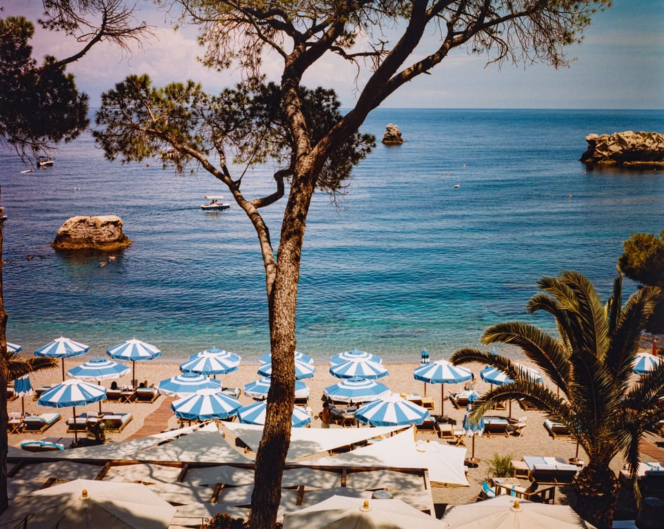 Blue loungers and umbrellas at Villa Sant’Andrea’s private beach