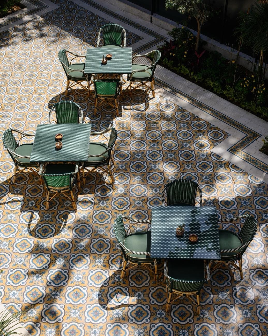 Outdoor dining tables on a patterned courtyard at Villa Belle Époque