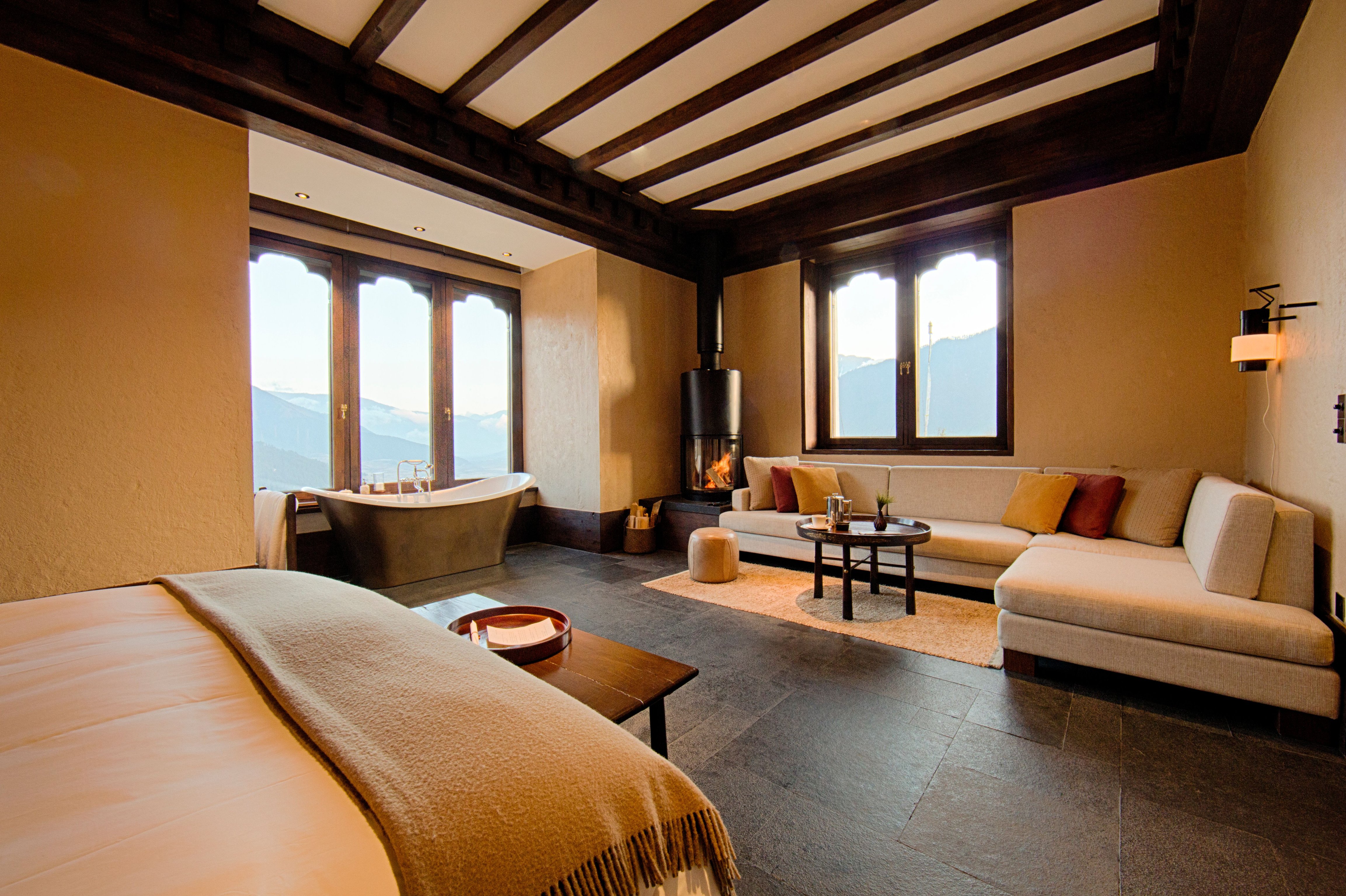 Suite with a sitting area and exposed beams at Gangtey Lodge