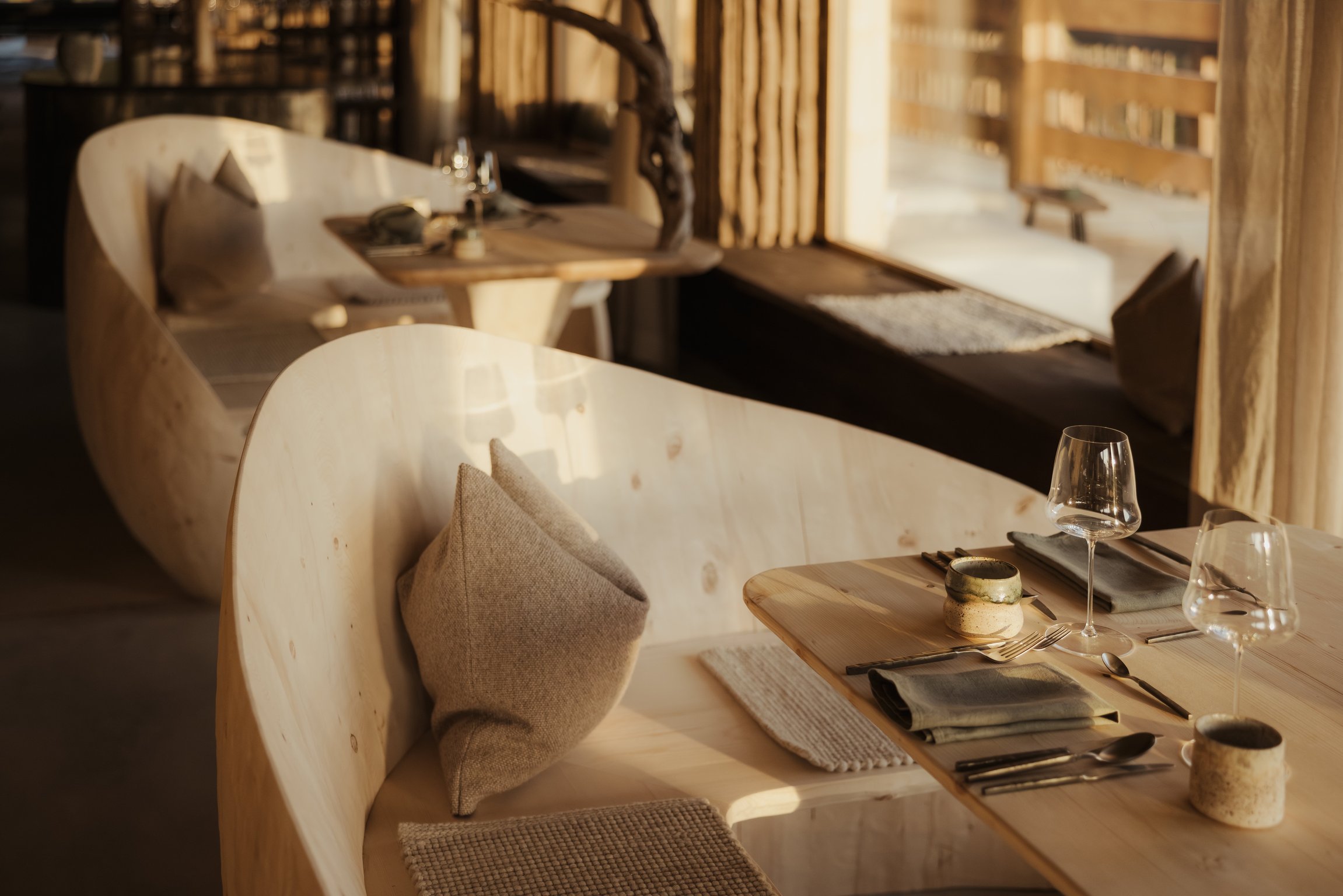 Curved wooden dining banquette and table at Eriro Hotel