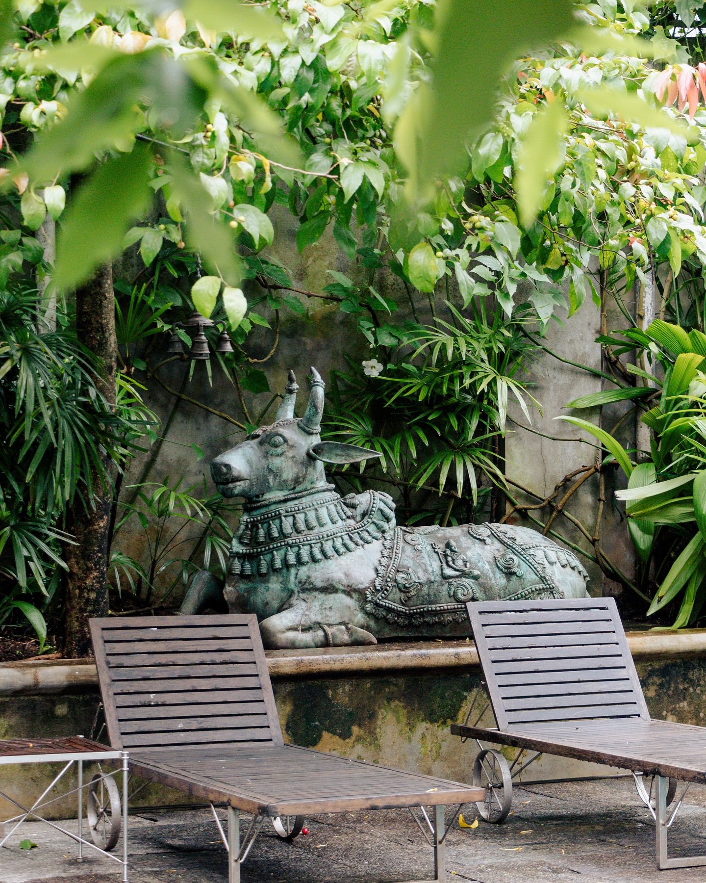 Garden sculpture and loungers in Maniumpathy’s tropical courtyard