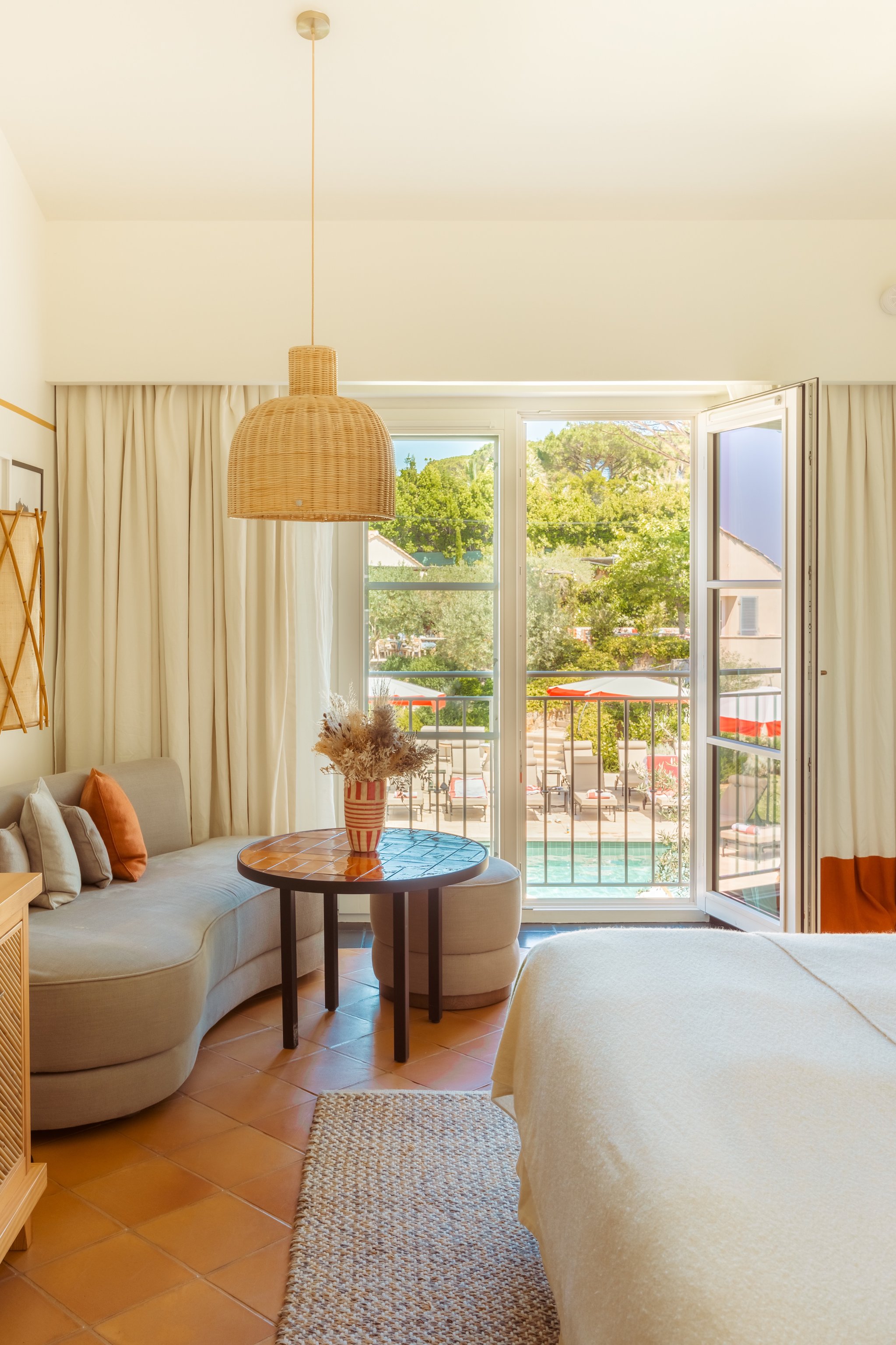 Sunlit guest room opening onto a terrace at Hôtel Lou Pinet