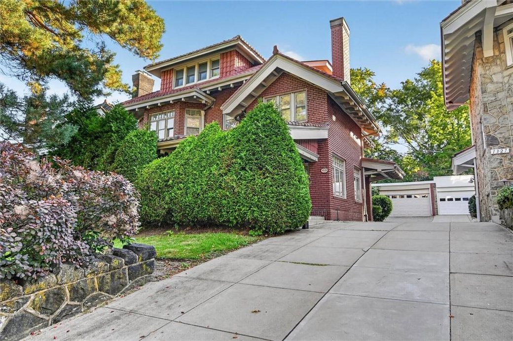 The brick front of 1321 Beechwood Boulevard behind tall hedges