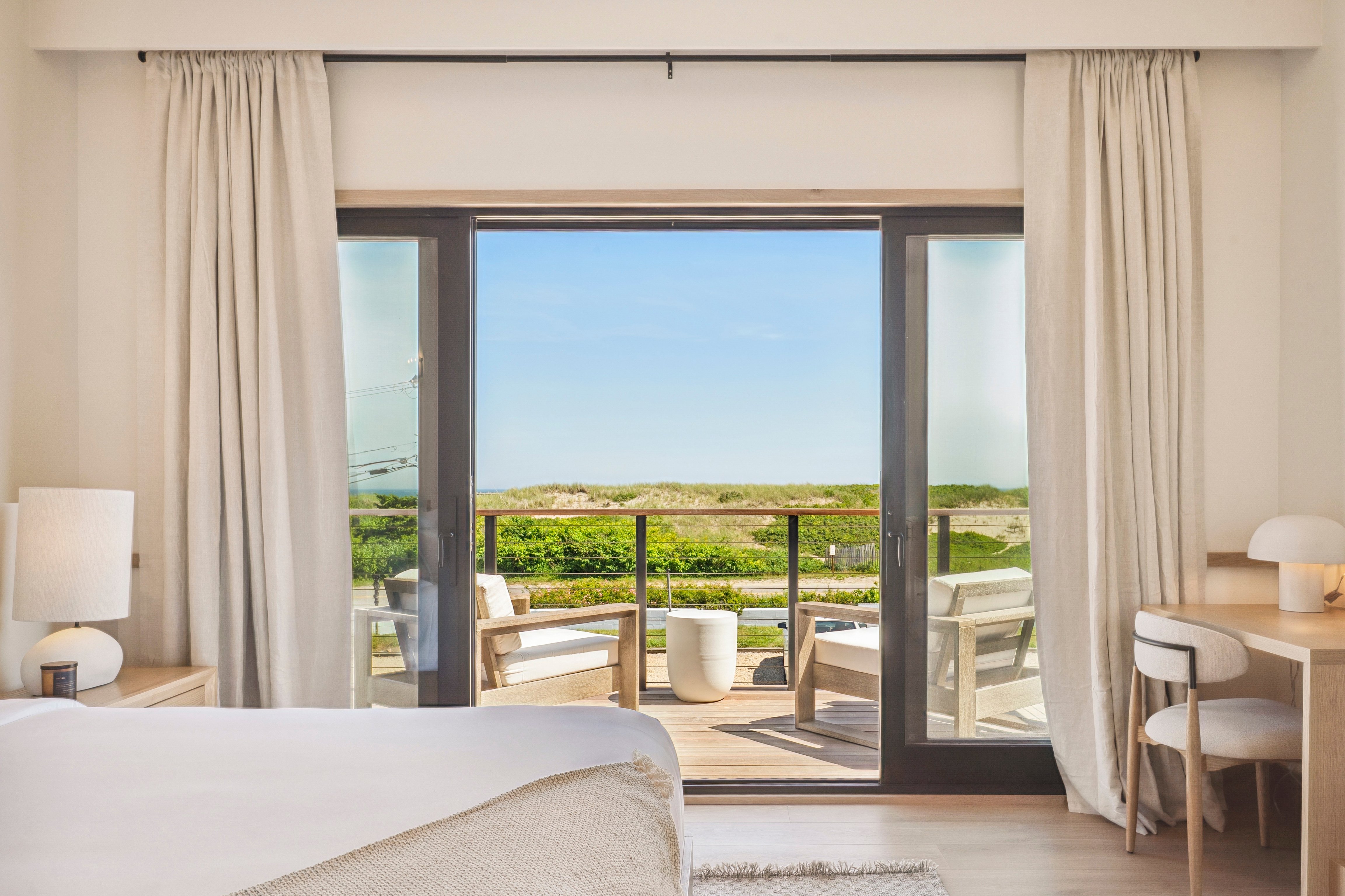 Bright Offshore Montauk guest room opening toward beach dunes