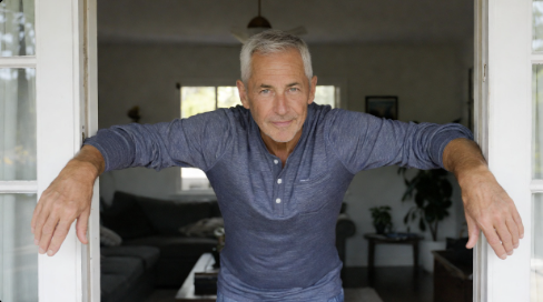 Man standing in a doorway stretching his chest muscles