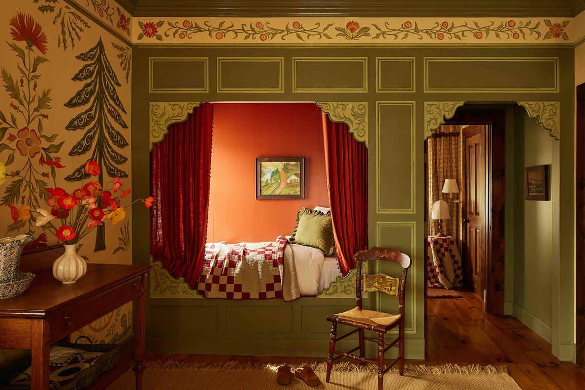 A curtained box bed framed by green painted woodwork at The Six Bells Countryside Inn.