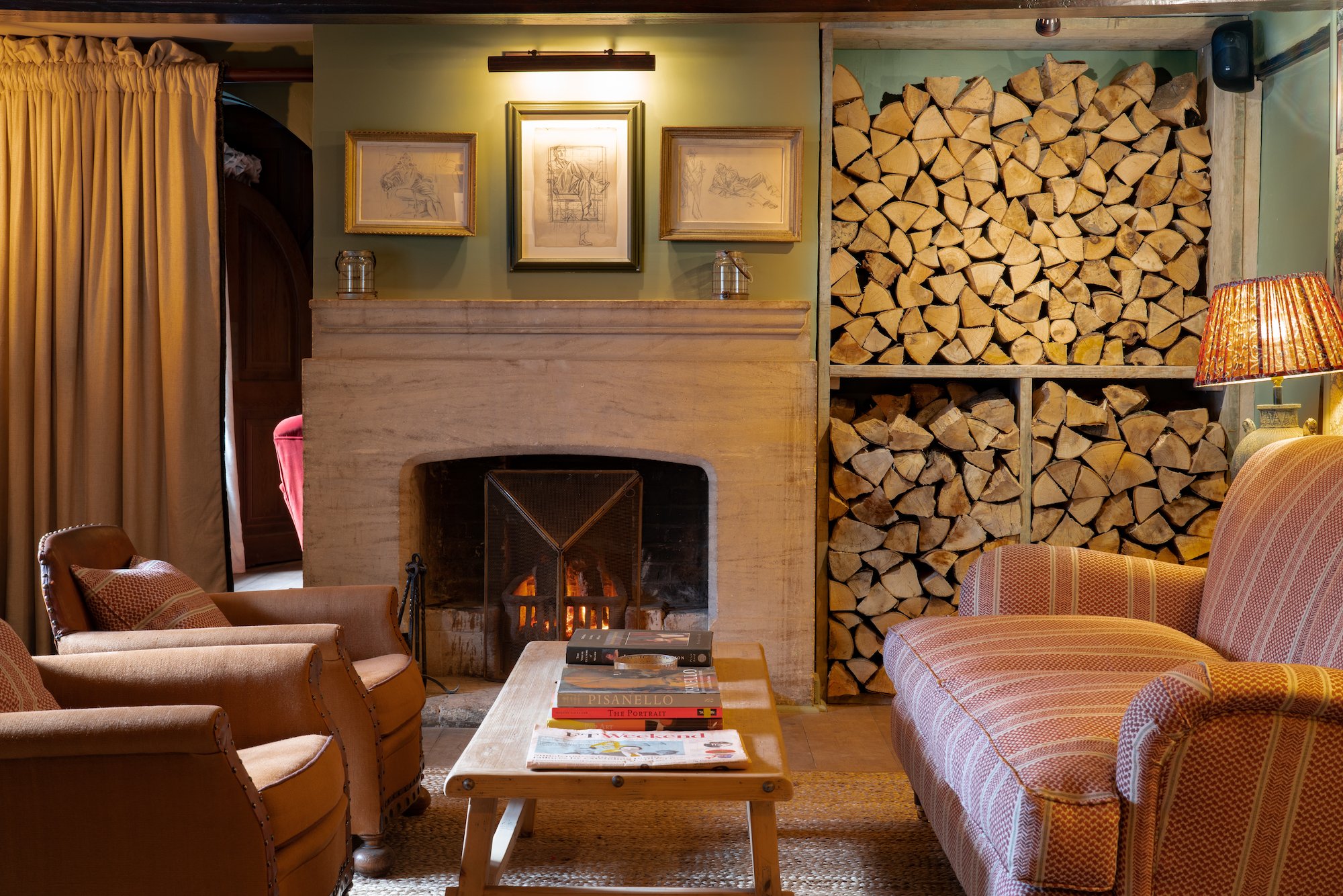 Fireplace lounge with stacked logs at The Double Red Duke