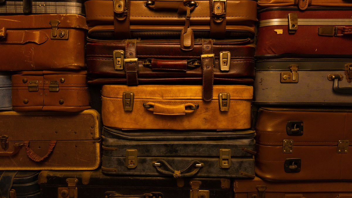 Rows of unclaimed suitcases on shelves in a warehouse