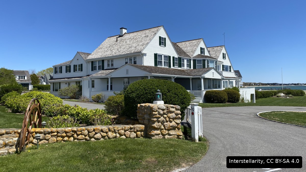 The white shingled main house of the Kennedy Compound in Hyannis Port under a clear blue sky
