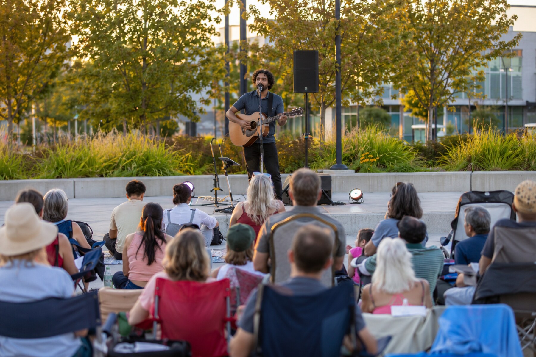 Solo guitarist performing an outdoor evening concert for a seated community audience in North Delta