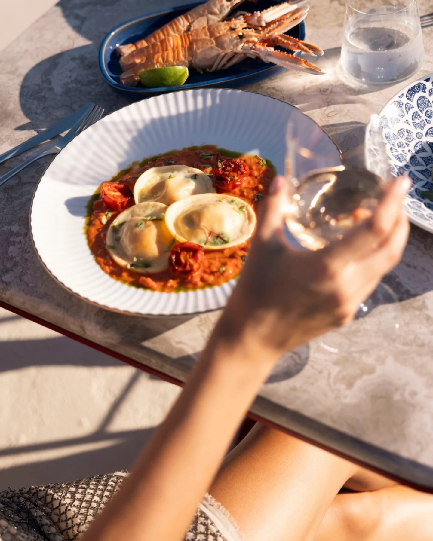 Guest dining outdoors with Mediterranean dishes and grilled seafood