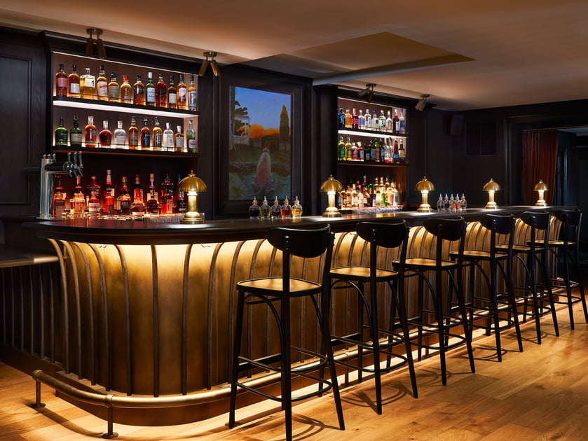 Dark wood bar with illuminated shelving at Stockton Inn