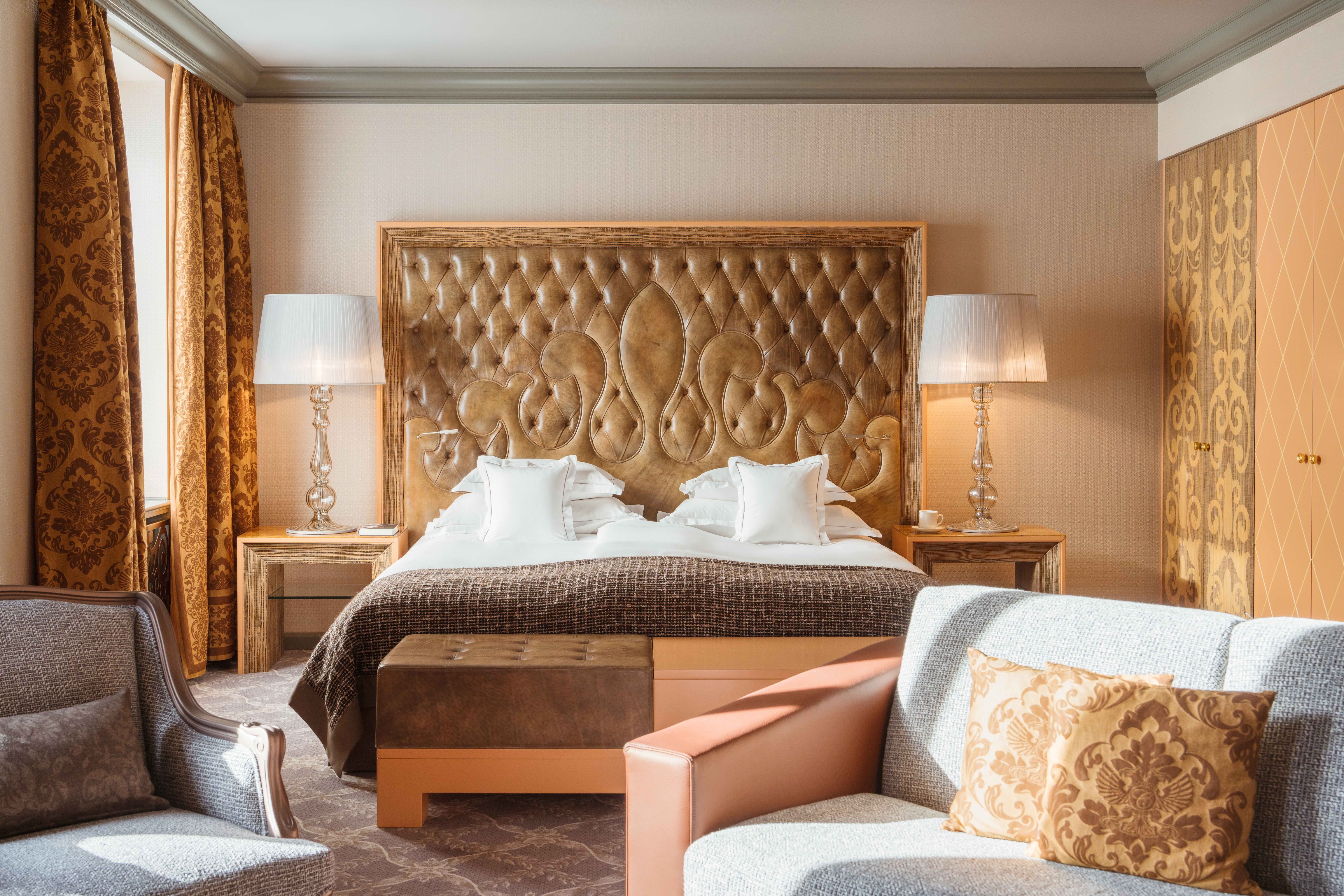 Guest bedroom with a tall tufted headboard at Carlton Hotel St. Moritz