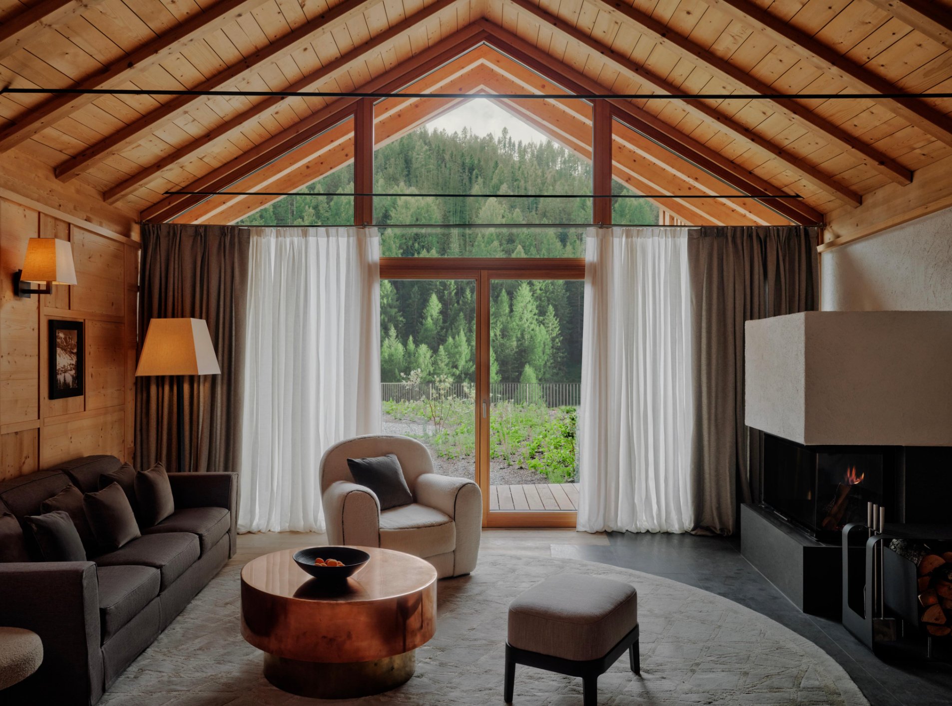 Wood-beamed Aman Rosa Alpina suite overlooking alpine greenery