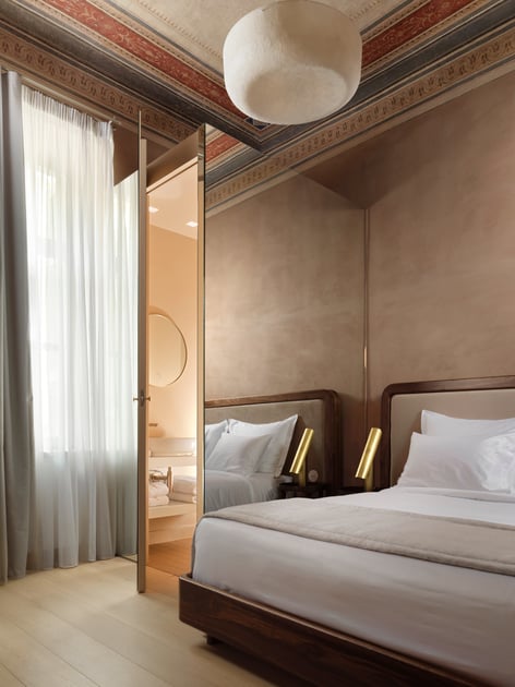 Guest bedroom beneath a restored decorative ceiling