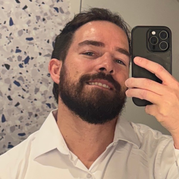 Adam taking a mirror selfie in a white shirt