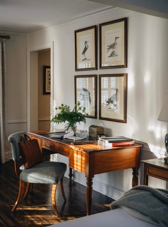 Curated artwork above a wooden desk at Wickwood Inn