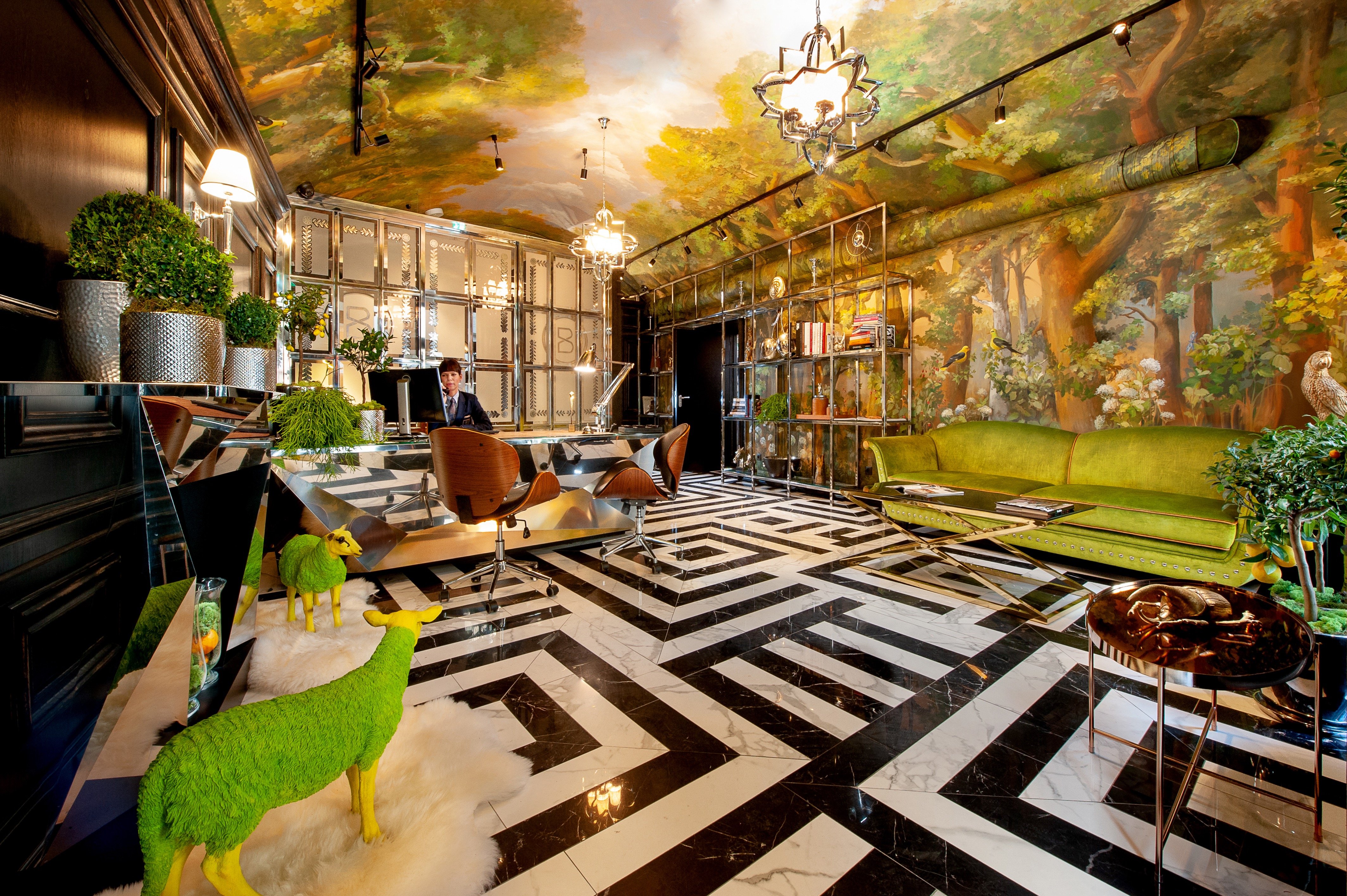 Mural-covered lobby with green velvet seating at Balthazar Design Hotel