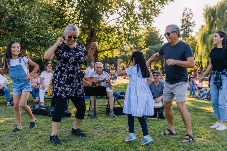 Families dancing together at a free outdoor Neighbourhood Play Days gathering in Richmond BC