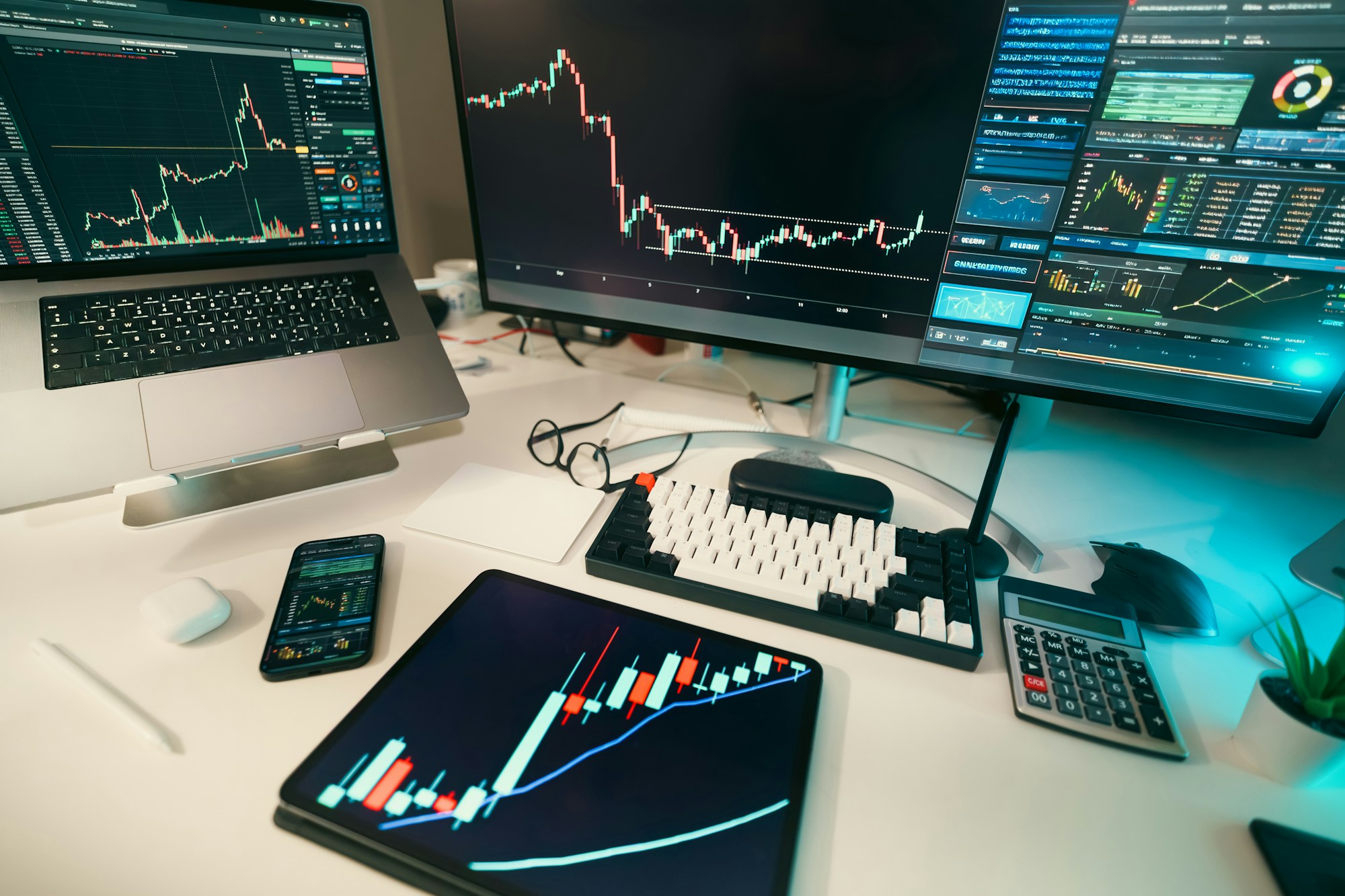 Candlestick stock market charts displayed on multiple screens