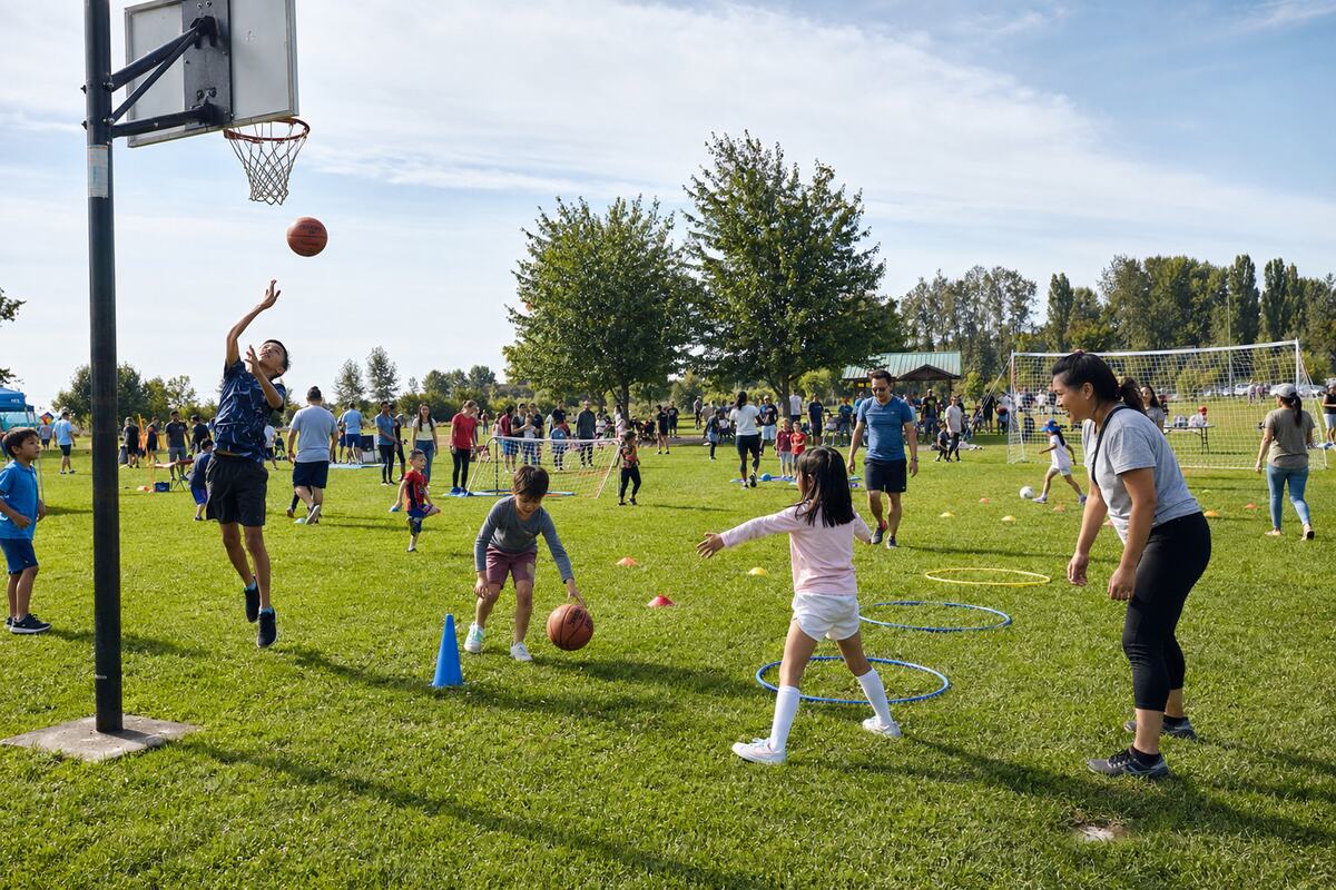 Children and parents enjoying outdoor sports stations at South Arm Community Park