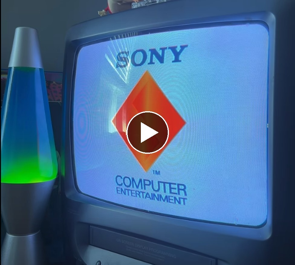 An old CRT TV showing the original PlayStation boot screen next to a lava lamp (play video)