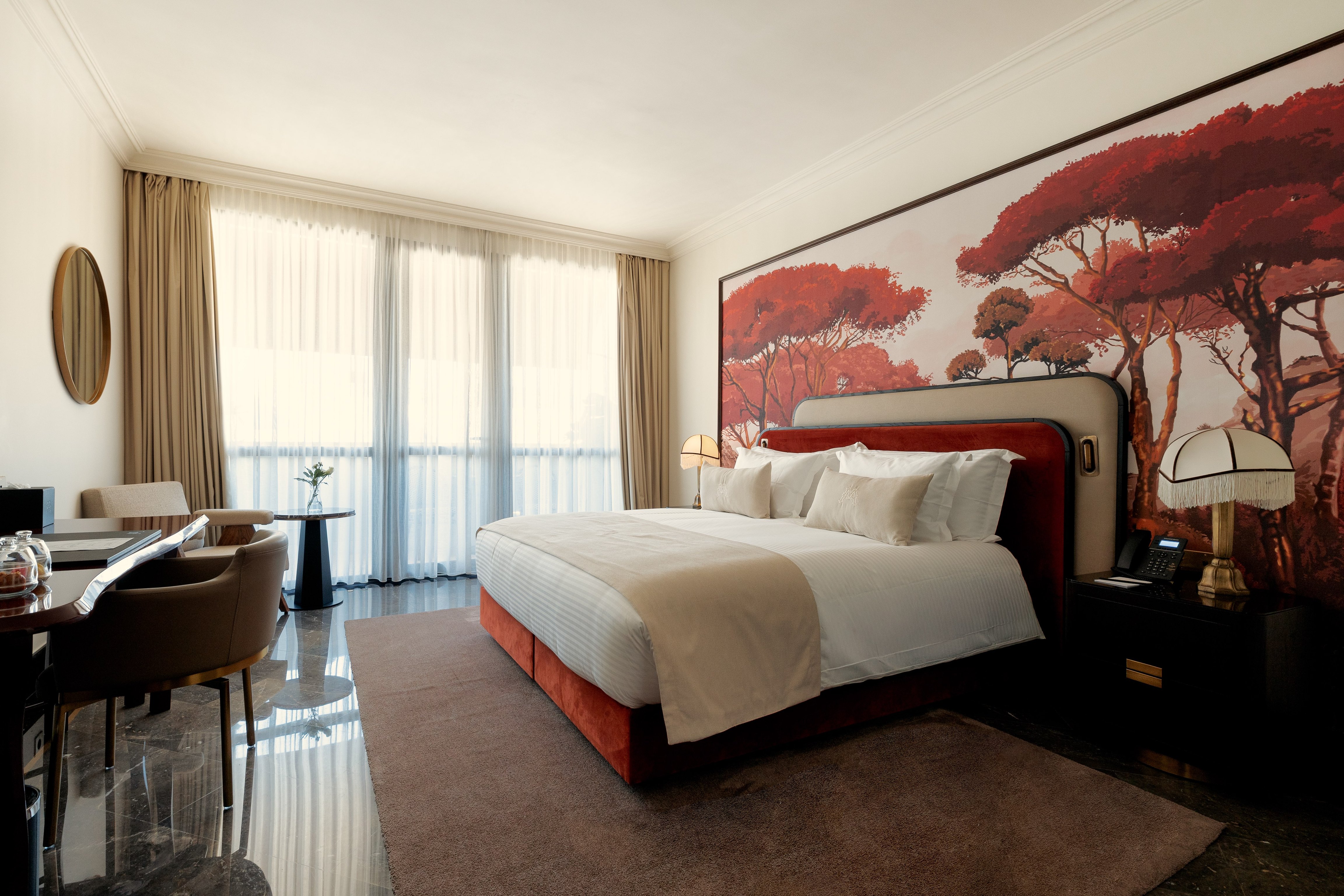 Guest room with a red botanical mural at Marly Boutique Hotel