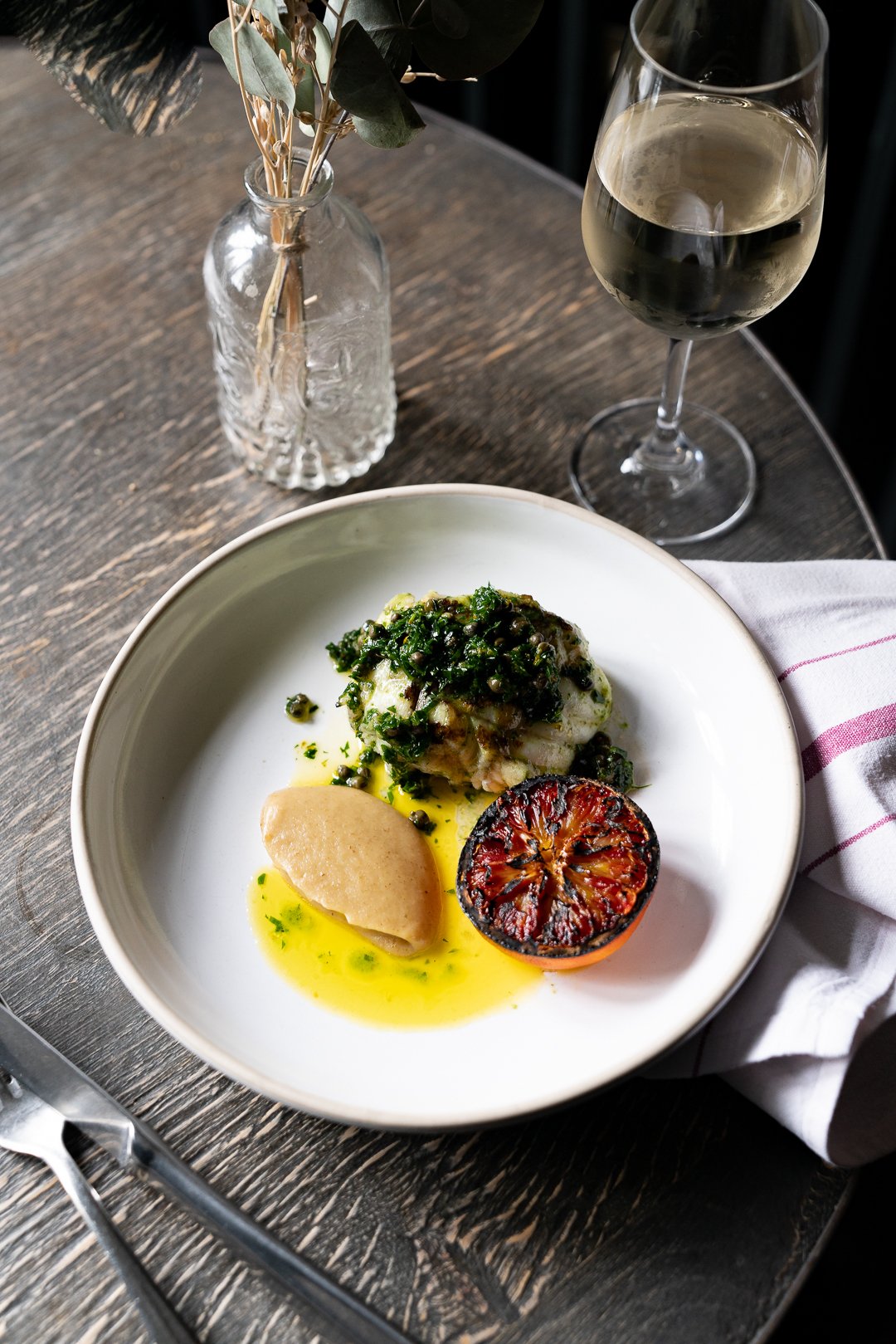 Plated fish with greens and charred lemon at The Double Red Duke