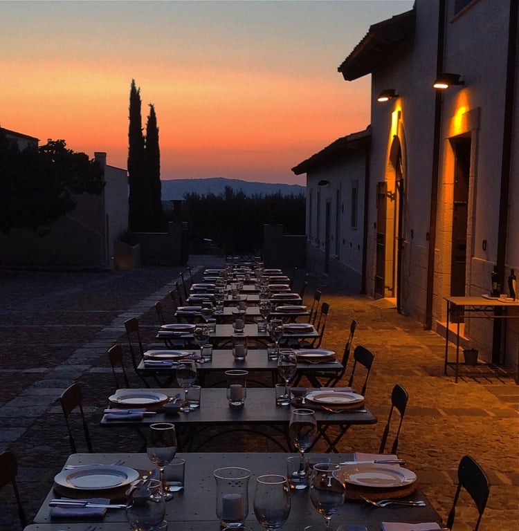 Outdoor dinner tables at sunset at Azienda Agricola Mandranova