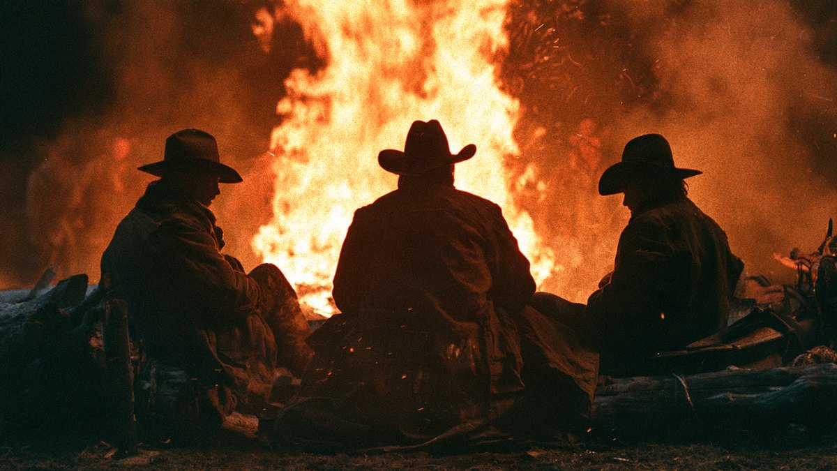 Ancient humans gathered around a campfire at night