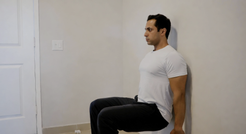 Man doing a simple wall sit exercise