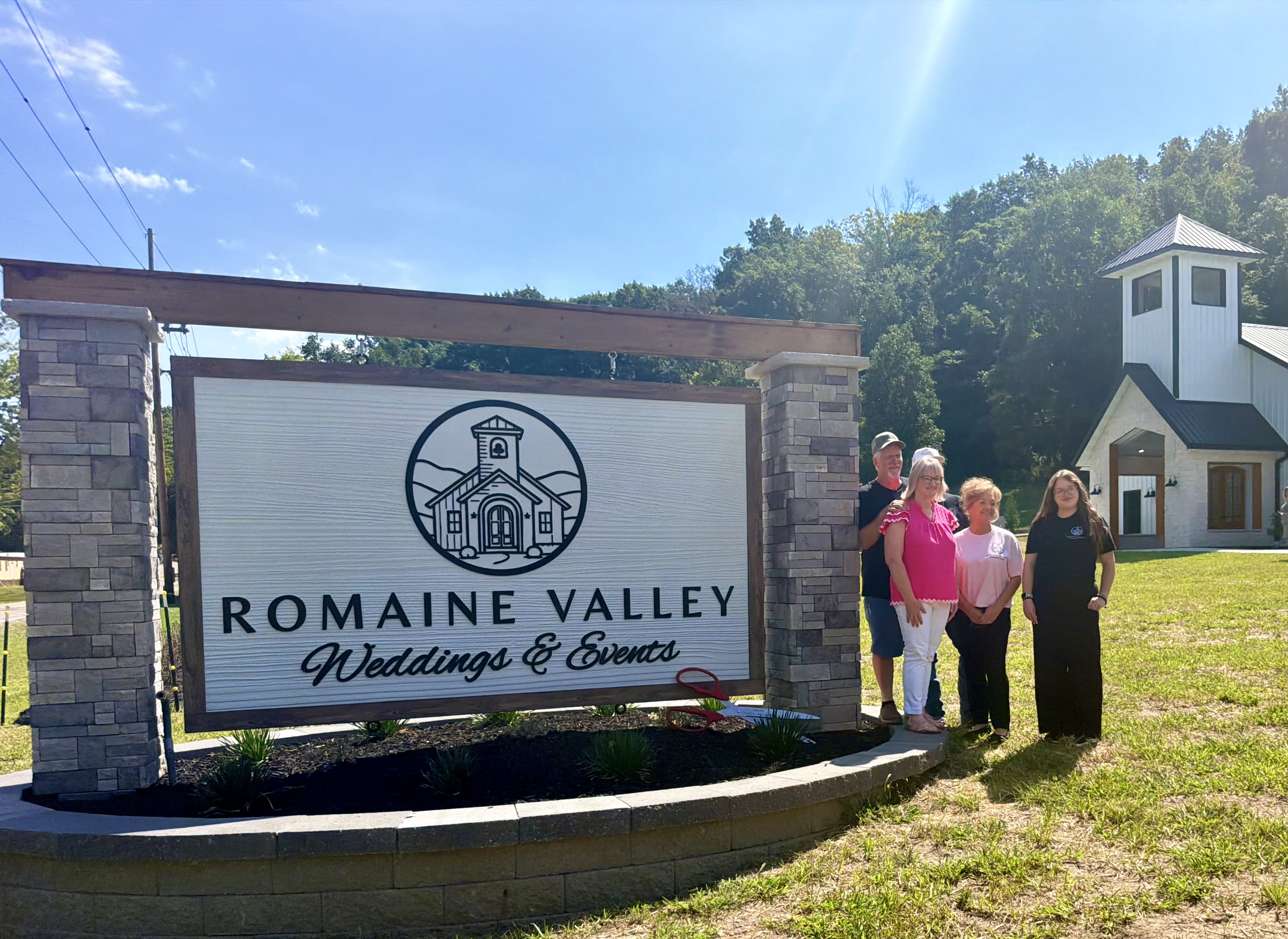 Romaine Valley owners and team beside the sign