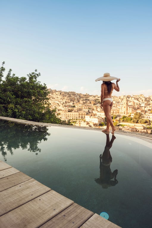 Guest beside the pool with views over Modica at Casa Talia