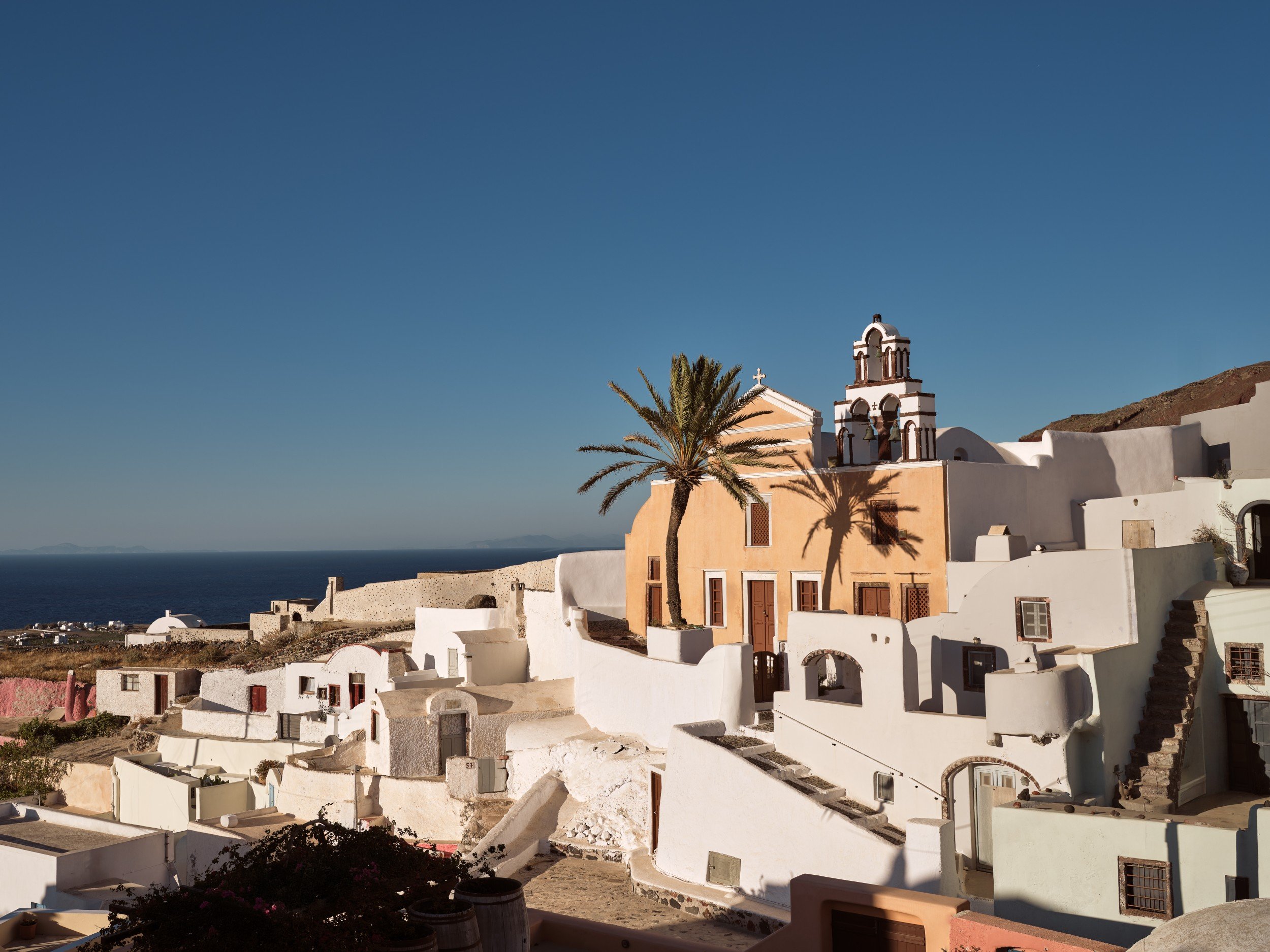 Whitewashed Finikia village and a domed church overlooking the Aegean Sea