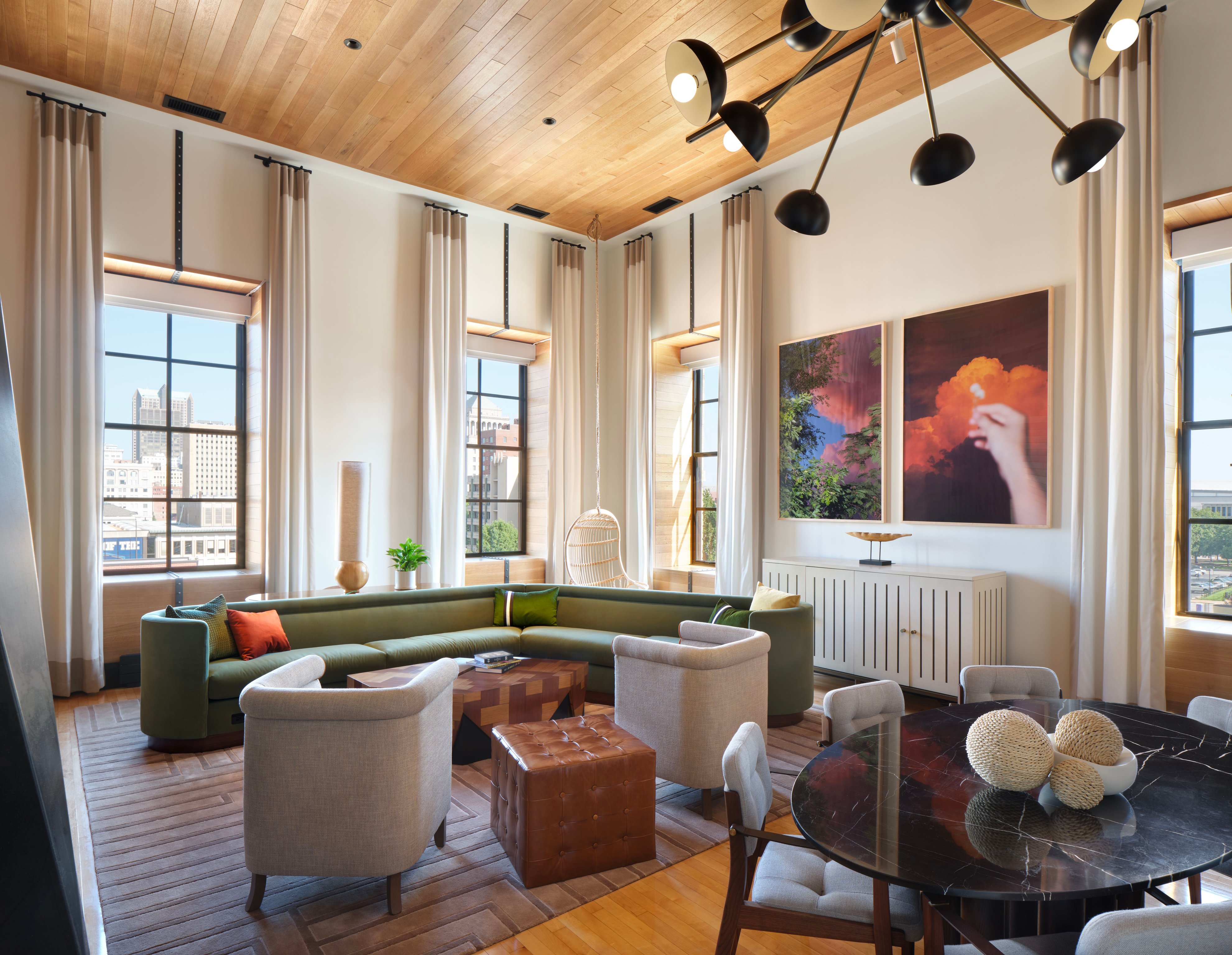 Guest suite seating area with tall windows and artwork at 21c Museum Hotel St. Louis